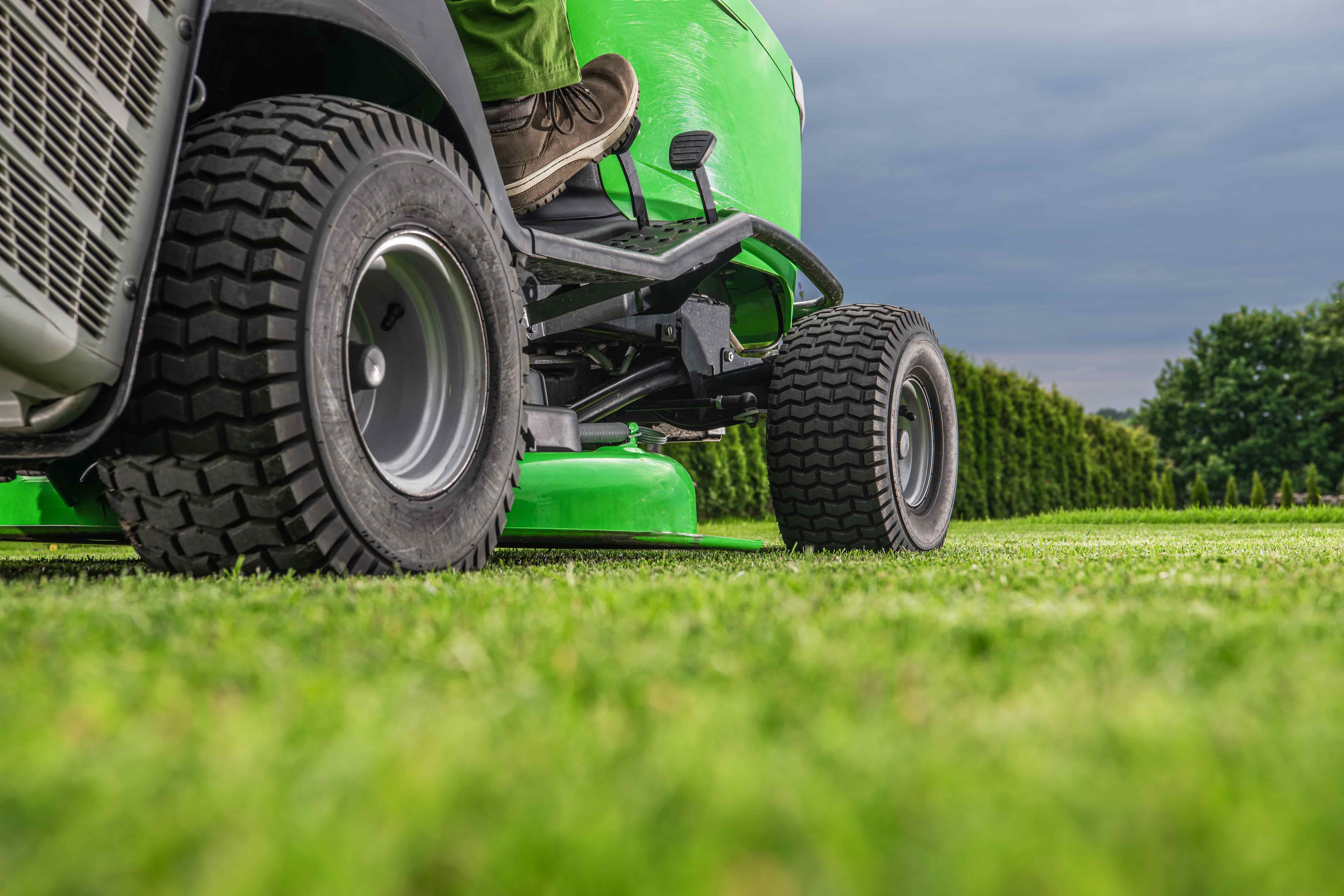 A green lawncare tractor has been fitted with R3 turf tires to minimize lawn damage as much as possible.