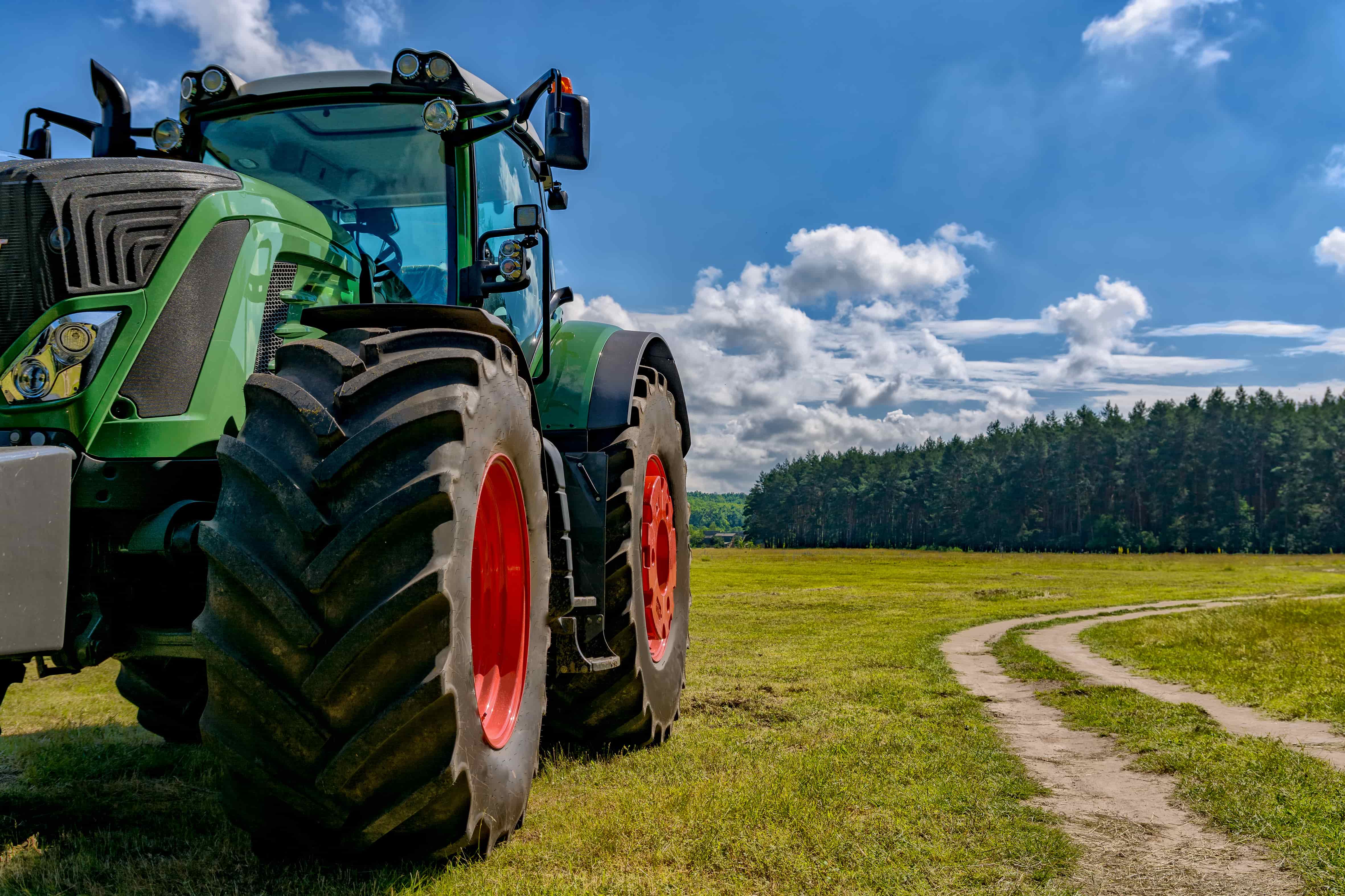 A green farm tractor that has been fitted with R1 agricultural tires for extra traction.
